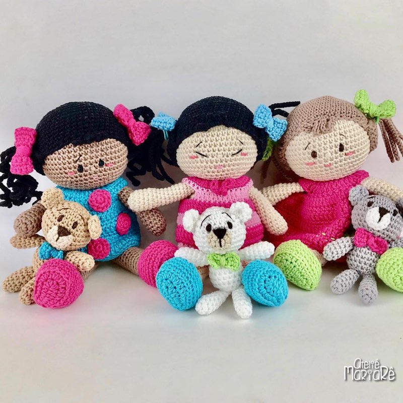 Grande grupo de bonecas e bichinhos de crochê amigurumi reunidos, com corações e pompons coloridos