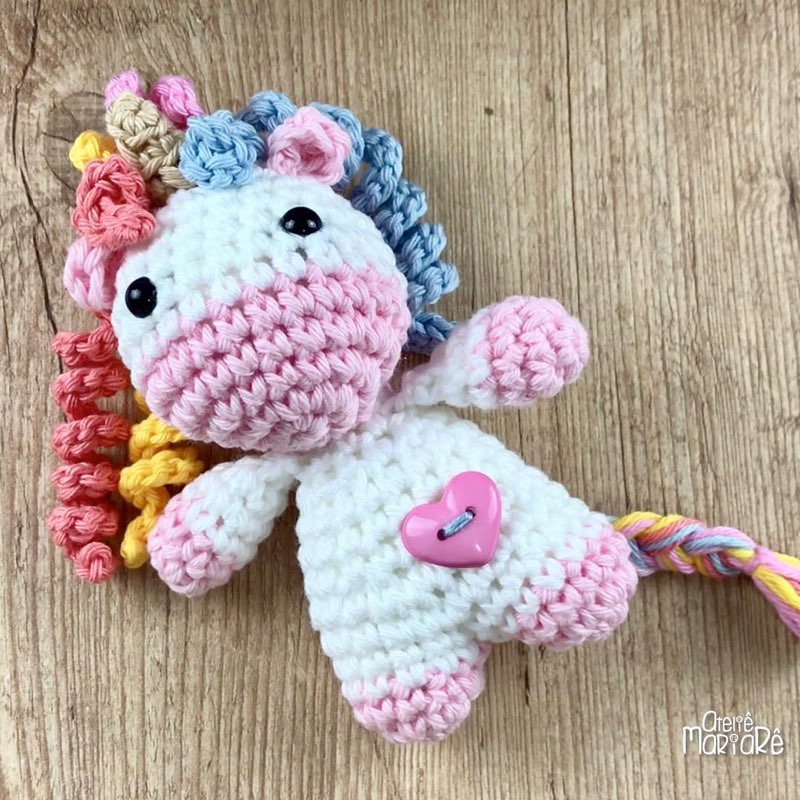 Unicórnio de crochê amigurumi branco e colorido, com juba e cauda em arco-íris
